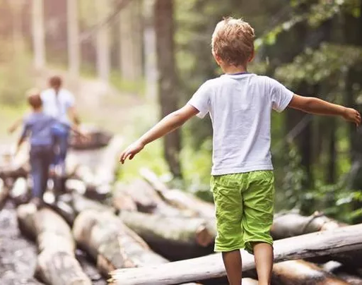 Enfant marchant sur un tronc