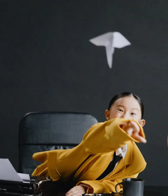 Enfant jettant un avion en papier