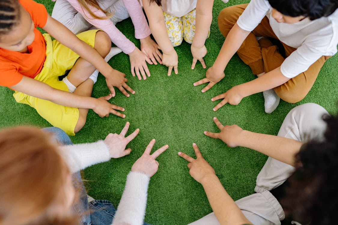 Enfants faisant classe dans l'herbe